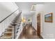 Bright hallway featuring hardwood floors, staircase, and an elegant table with stylish decorations at 700 Queen Charlottes Ct, Charlotte, NC 28211