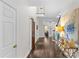 Wide hallway featuring hardwood floors, white walls, staircase, and decorative table at 700 Queen Charlottes Ct, Charlotte, NC 28211