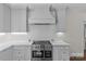 Renovated kitchen with stainless steel appliances, white cabinets, tile backsplash, and ample counter space at 700 Queen Charlottes Ct, Charlotte, NC 28211