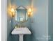 This powder room has gold fixtures and light blue patterned walls at 700 Queen Charlottes Ct, Charlotte, NC 28211