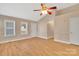 A spacious living room featuring wood floors, wainscoting, neutral paint and bright sunlight at 7905 Symphony Rd, Charlotte, NC 28216