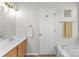 Well-maintained bathroom with a soaking tub, wood cabinets, and neutral color scheme at 8211 Poplar Grove Cir # 31, Waxhaw, NC 28173