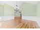 Open view of a dining room featuring hardwood floors, chandelier, and wainscoting at 9016 Heather Trce, Gastonia, NC 28056