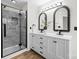 This bathroom features a stand-up shower, double vanity, and ornate lighting at 10211 Ridgewell Ct, Charlotte, NC 28215