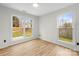 Bright bedroom featuring wood-look floors and natural light from two large windows at 10211 Ridgewell Ct, Charlotte, NC 28215