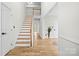 Inviting entryway featuring hardwood floors, staircase, and a view into other rooms, bright and airy at 10211 Ridgewell Ct, Charlotte, NC 28215