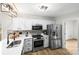 Modern kitchen with stainless steel appliances, white cabinetry, stylish backsplash, and ample counter space at 10211 Ridgewell Ct, Charlotte, NC 28215