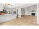 Open-concept living room featuring a fireplace, wood-look floors, and adjacent kitchen and dining areas at 10211 Ridgewell Ct, Charlotte, NC 28215