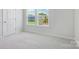 Bright bedroom with gray walls, plush carpet, and a large window overlooking the neighborhood at 113 Alluvium Ln, Waxhaw, NC 28173