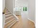 Entryway with wood floors, white trim, a staircase, and a glimpse into the open-concept kitchen and living area at 113 Alluvium Ln, Waxhaw, NC 28173