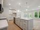 Bright, open kitchen features white cabinets, stainless appliances, an island, and seamless flow to the living area at 113 Alluvium Ln, Waxhaw, NC 28173