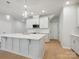 Bright, modern kitchen with white cabinets, a large island, stainless steel appliances, and stylish pendant lighting at 113 Alluvium Ln, Waxhaw, NC 28173