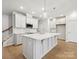 Modern kitchen with white cabinets, quartz countertops, stainless steel appliances, and a large center island at 113 Alluvium Ln, Waxhaw, NC 28173