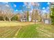 Large backyard with a storage shed and ample space for outdoor activities with mature trees around the property at 116 Miller Farm Rd, Statesville, NC 28625