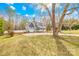 Beautiful house with an attached garage surrounded by a spacious lawn and mature trees on a sunny day at 116 Miller Farm Rd, Statesville, NC 28625