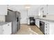 Bright kitchen featuring tile flooring, white cabinets, and modern stainless steel appliances at 116 Miller Farm Rd, Statesville, NC 28625