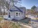 Side view of a gray two-story home, featuring a detached garage with white doors and a well-maintained lawn at 11611 Old Aquadale Rd, Norwood, NC 28128