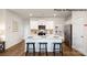 Modern kitchen with white cabinets, an island with seating, and stainless steel appliances at 123 Meadowview Dr, Statesville, NC 28677
