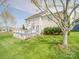 A well-maintained backyard features a deck, lush lawn, and mature tree providing shade and beauty at 139 Tenth Green Ct, Statesville, NC 28625