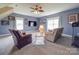 Large living room with seating, ceiling fan, and ample natural light at 139 Tenth Green Ct, Statesville, NC 28625