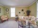 Cozy living room with bright green walls, floral seating and natural light at 139 Tenth Green Ct, Statesville, NC 28625