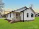 Beautiful white house with black trim, an entrance to the backyard, and a spacious lawn at 141 Ark St, Kings Mountain, NC 28086