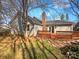 Home backyard with a wooden deck, brick chimney, and mature trees at 14106 Carriage Lake Dr, Charlotte, NC 28273