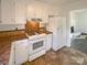 Cozy kitchen with white cabinets and view into another room with fireplace at 14106 Carriage Lake Dr, Charlotte, NC 28273