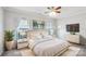Bright bedroom features a gold-accented bed, stylish nightstands, and a modern dresser with a wall-mounted TV at 1426 Whitman Ct, York, SC 29745