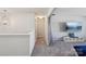 Hallway with carpet and a ceiling light fixture leads into the living room with large TV at 1426 Whitman Ct, York, SC 29745