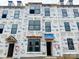 View of new construction townhome with Barricade wrap, dormer windows, and covered entryway at 15332 Ballancroft Pkwy # 17, Charlotte, NC 28277
