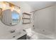 Clean and well-lit bathroom has a bathtub with shower and wooden storage shelves at 159 Creekwood Dr, Mooresville, NC 28117