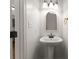 Bright half bath features a modern pedestal sink and updated fixtures next to the kitchen at 159 Creekwood Dr, Mooresville, NC 28117