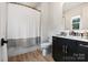 Modern bathroom featuring a shower with gray-striped curtain, elegant vanity, and bronze hardware at 16112 Terry Ln, Huntersville, NC 28078