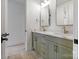 Bathroom with double sinks, marble countertops, green cabinetry, and modern fixtures at 16112 Terry Ln, Huntersville, NC 28078