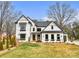 Striking two-story white home with black trim, complemented by a lush lawn and tasteful landscaping at 16112 Terry Ln, Huntersville, NC 28078