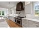 Modern kitchen with custom range hood, quartz countertops, and stainless steel appliances at 16112 Terry Ln, Huntersville, NC 28078