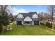 Stunning white farmhouse with black trim, showcasing a spacious backyard and seamless indoor-outdoor living at 16112 Terry Ln, Huntersville, NC 28078