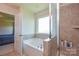 Bright bathroom featuring a soaking tub, glass shower, and tiled walls at 173 Glastonbury Dr, Mooresville, NC 28115