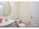 Cozy powder room featuring a pedestal sink, toilet, and neutral decor with a round mirror at 173 Glastonbury Dr, Mooresville, NC 28115