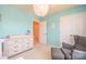 Bedroom with aqua walls and a window with a comfortable gray chair and ottoman at 173 Glastonbury Dr, Mooresville, NC 28115