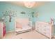 A bedroom with aqua walls, decorated with a tree decal and a whimsical chandelier at 173 Glastonbury Dr, Mooresville, NC 28115