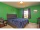 A green bedroom features a queen-sized bed, bedside table, window with curtains, and a wall shelf at 173 Glastonbury Dr, Mooresville, NC 28115