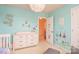 Light-filled bedroom with aqua walls, featuring a white dresser and playful decor at 173 Glastonbury Dr, Mooresville, NC 28115