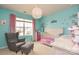 Charming bedroom with aqua walls, plush chair, and a crib, bathed in natural light from a large window at 173 Glastonbury Dr, Mooresville, NC 28115