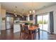 Cozy dining area features dark wood table, stainless steel appliances, and outdoor access at 173 Glastonbury Dr, Mooresville, NC 28115