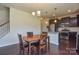 Open dining area featuring a chandelier and hardwood floors connecting to a kitchen with stainless steel appliances at 173 Glastonbury Dr, Mooresville, NC 28115