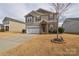Charming two-story home with stone accents, well-manicured lawn, and two car garage at 173 Glastonbury Dr, Mooresville, NC 28115