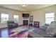 Cozy living room with a fireplace, modern furniture, large TV, and plenty of natural light at 173 Glastonbury Dr, Mooresville, NC 28115
