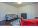 Cozy living room showcasing a gray sofa, red armchair, dark floors, and a neutral-toned rug at 173 Glastonbury Dr, Mooresville, NC 28115